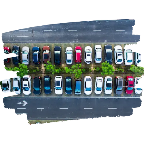 道路を挟んで両側に整然と並んだ車両が写る、上空から撮影した駐車場の空撮画