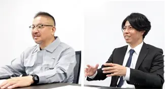作業服姿とスーツ姿のユーザー企業担当者2名がAMmeister導入について対談している様子