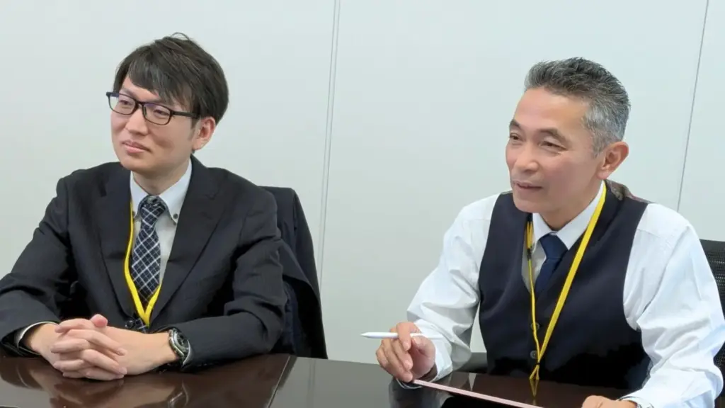 ユニプレス株式会社の担当者2名が会議テーブルで対談している写真