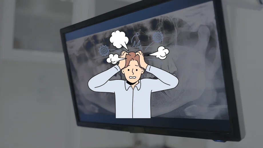 歯科用レントゲン画像の前に、頭を抱えて頭痛に悩む男性のイラストが表示されたモニター