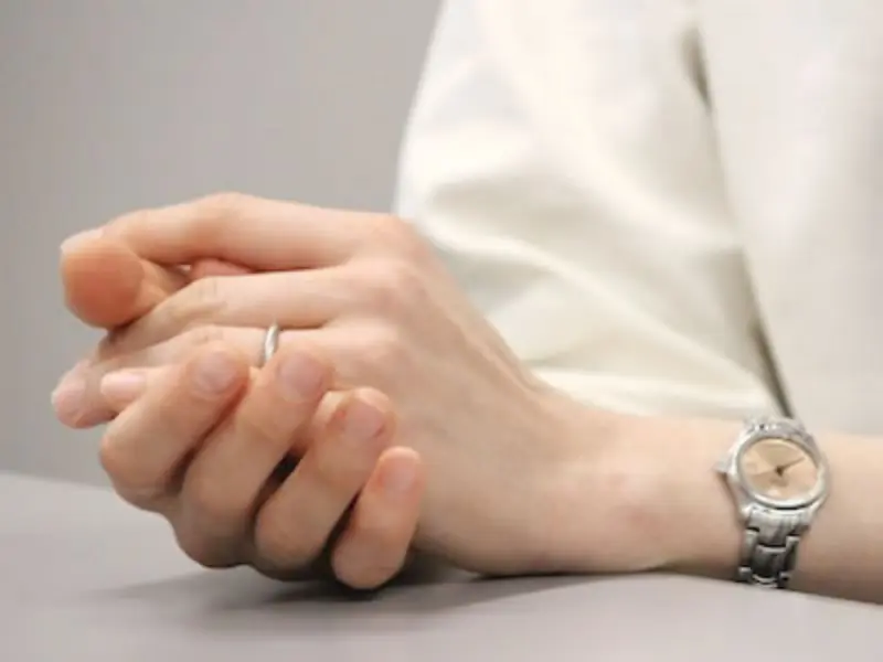 インタビュー中、テーブル上で指を組む木村さんの手元クローズアップ。結婚指輪が印象的。