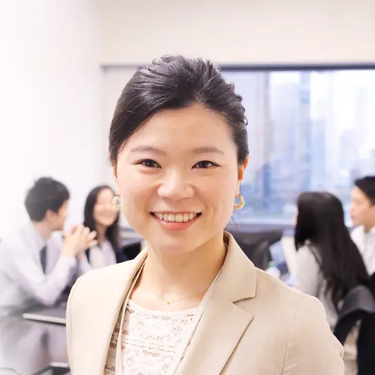 会議室でほほえむ女性社員のバストアップ。