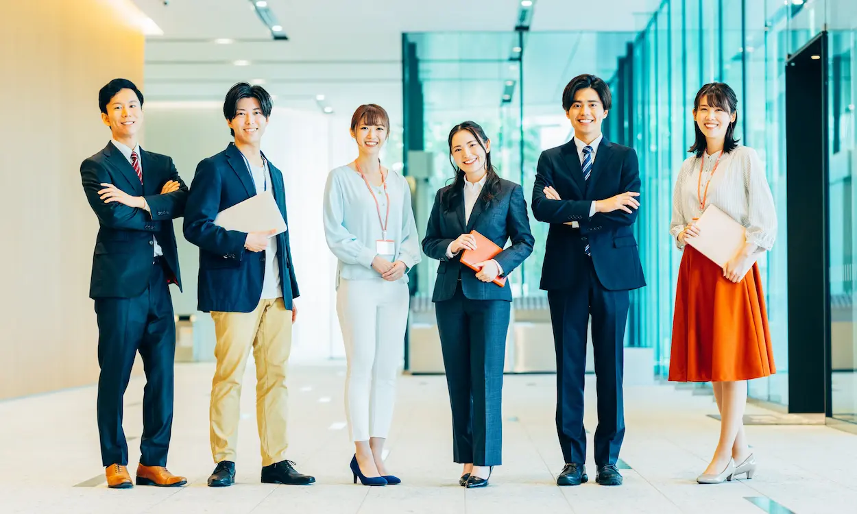 オフィスで並ぶ若手社員たちの集合写真