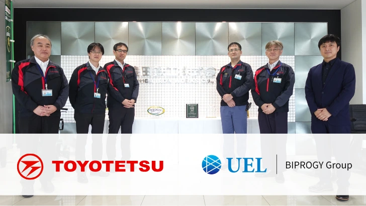 CiPHub導入事例として豊田鉄工とUELの担当者6名がロビーで並び、写真下部にTOYOTETSUとUELのロゴを配置した集合写真