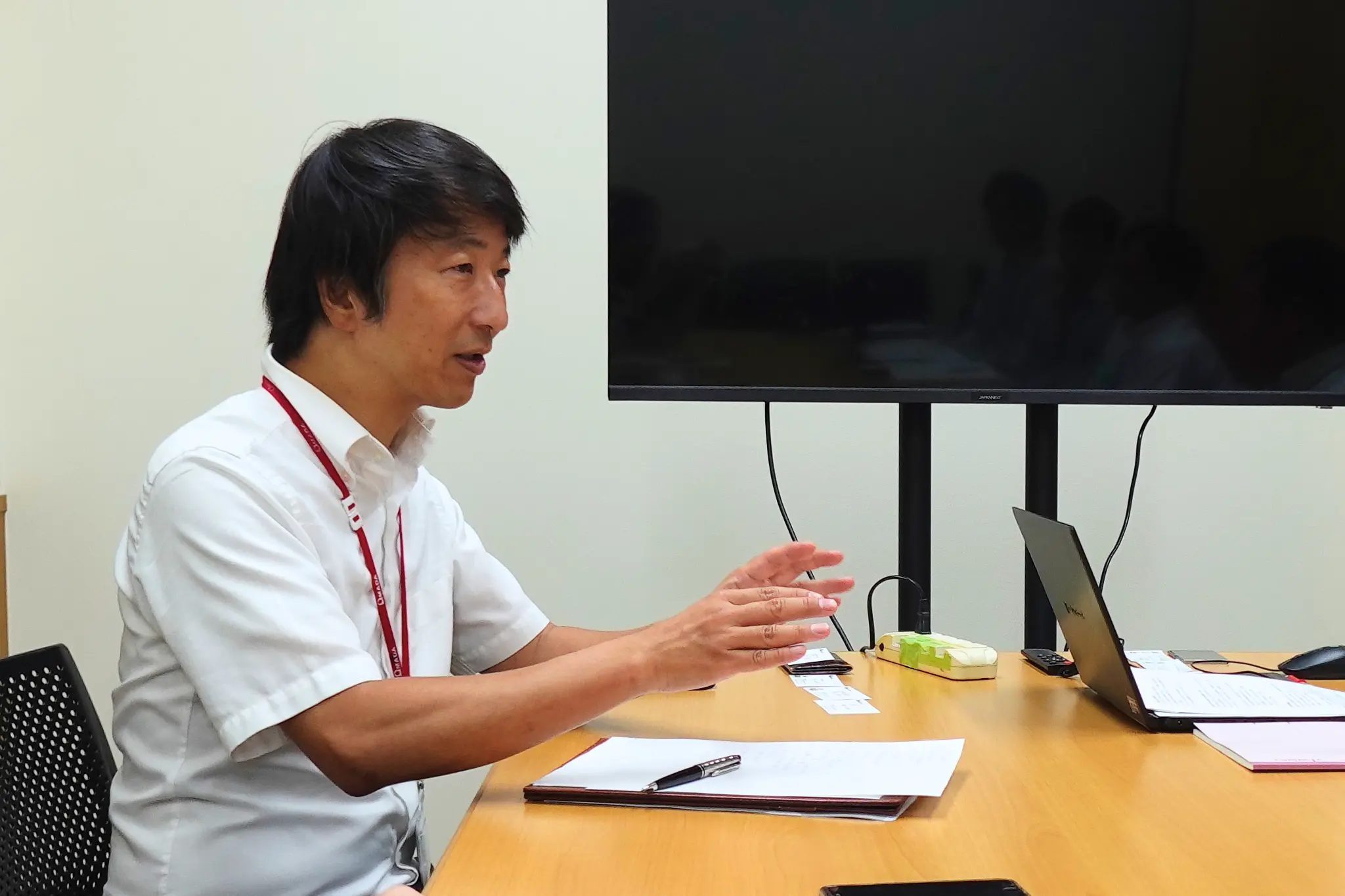 会議室で担当者がプレゼンしながら語るインタビュー。UEL社員が顧客とコミュニケーションをとるシーン。